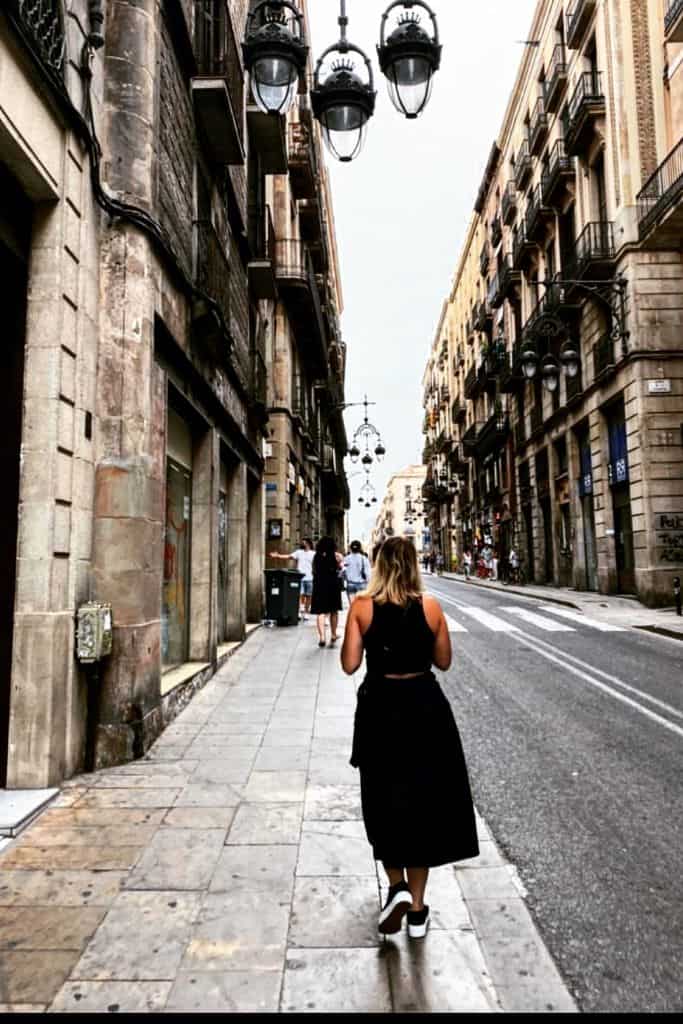 Expat strolling down a narrow alley street in Barcelona