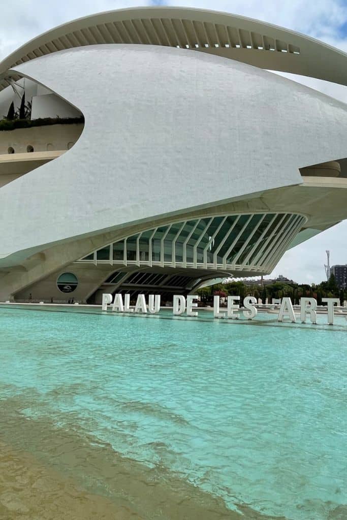 Palau de Les Art white opera house on top of bright a bright blue water pond